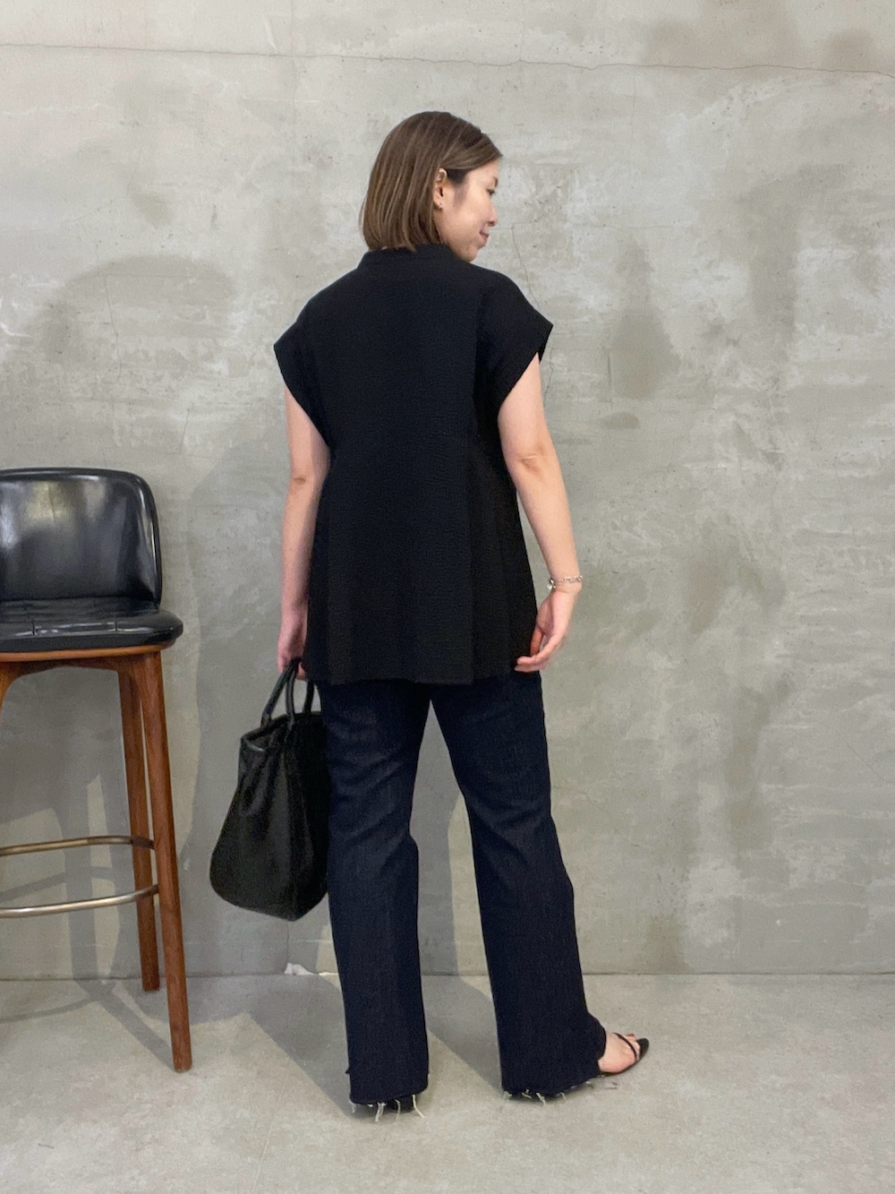 ブラック系のシャツ/ブラウス、ブルー系のデニムパンツ、ブラック系のトートバッグを着用したレディースの夏コーディネートの3枚目の写真