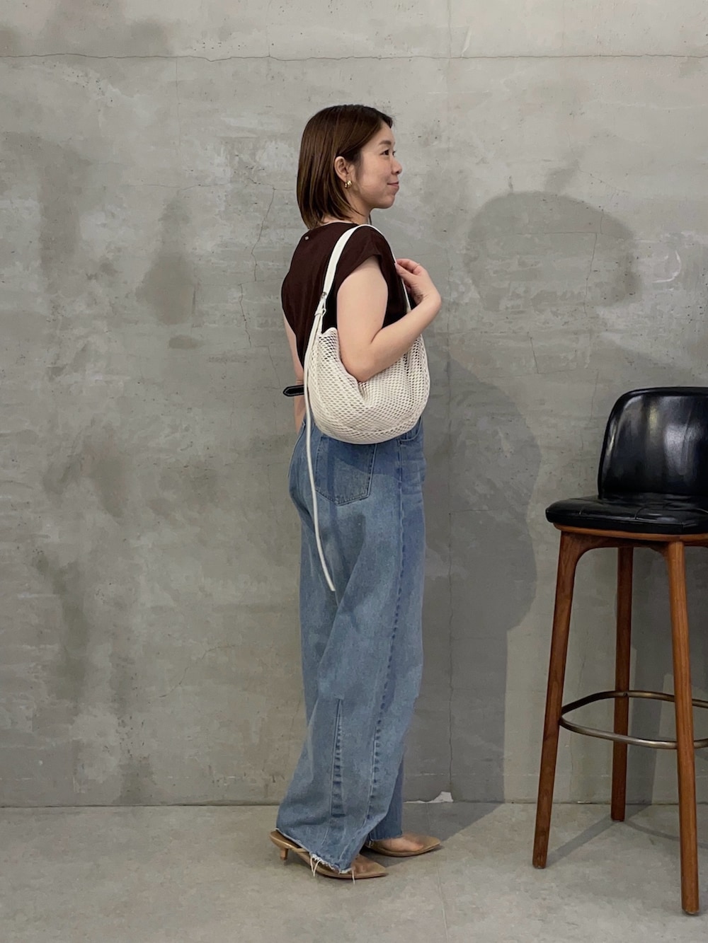 ブラウン系のTシャツ/カットソー、ブルー系のデニムパンツ、ホワイト系のショルダーバッグを着用したレディースの春コーディネートの2枚目の写真