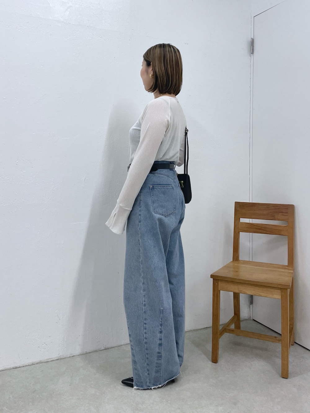 ホワイト系のTシャツ/カットソー、ブルー系のデニムパンツ、ブラック系のベルトを着用したレディースの秋コーディネートの2枚目の写真