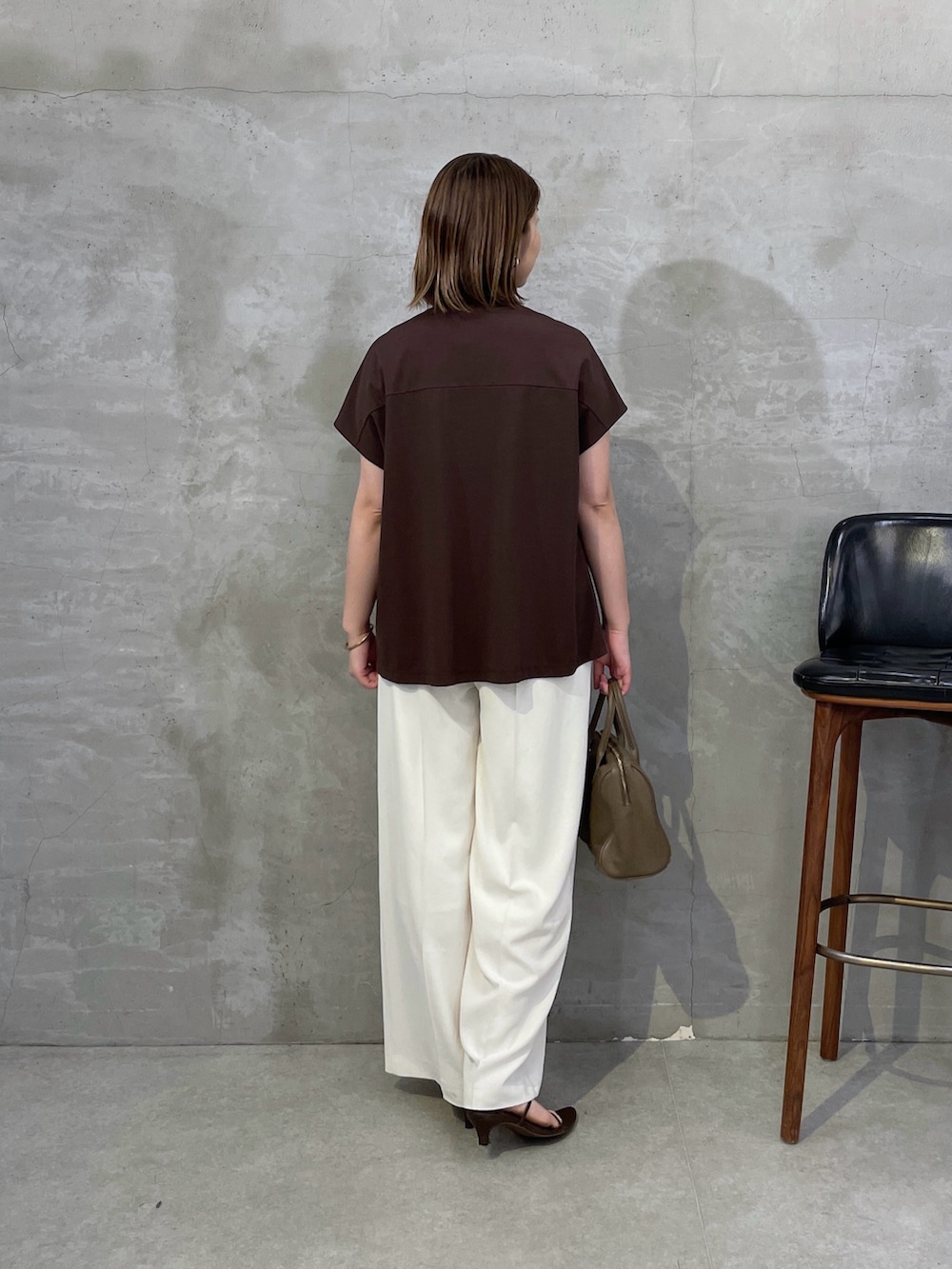 ブラウン系のTシャツ/カットソー、ホワイト系のスラックス、ブラウン系のボストンバッグを着用したレディースの夏コーディネートの3枚目の写真