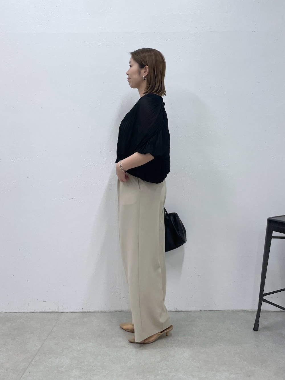 ブラック系のTシャツ/カットソー、ベージュ系のスラックス、ブラック系のボストンバッグを着用したレディースの夏コーディネートの3枚目の写真