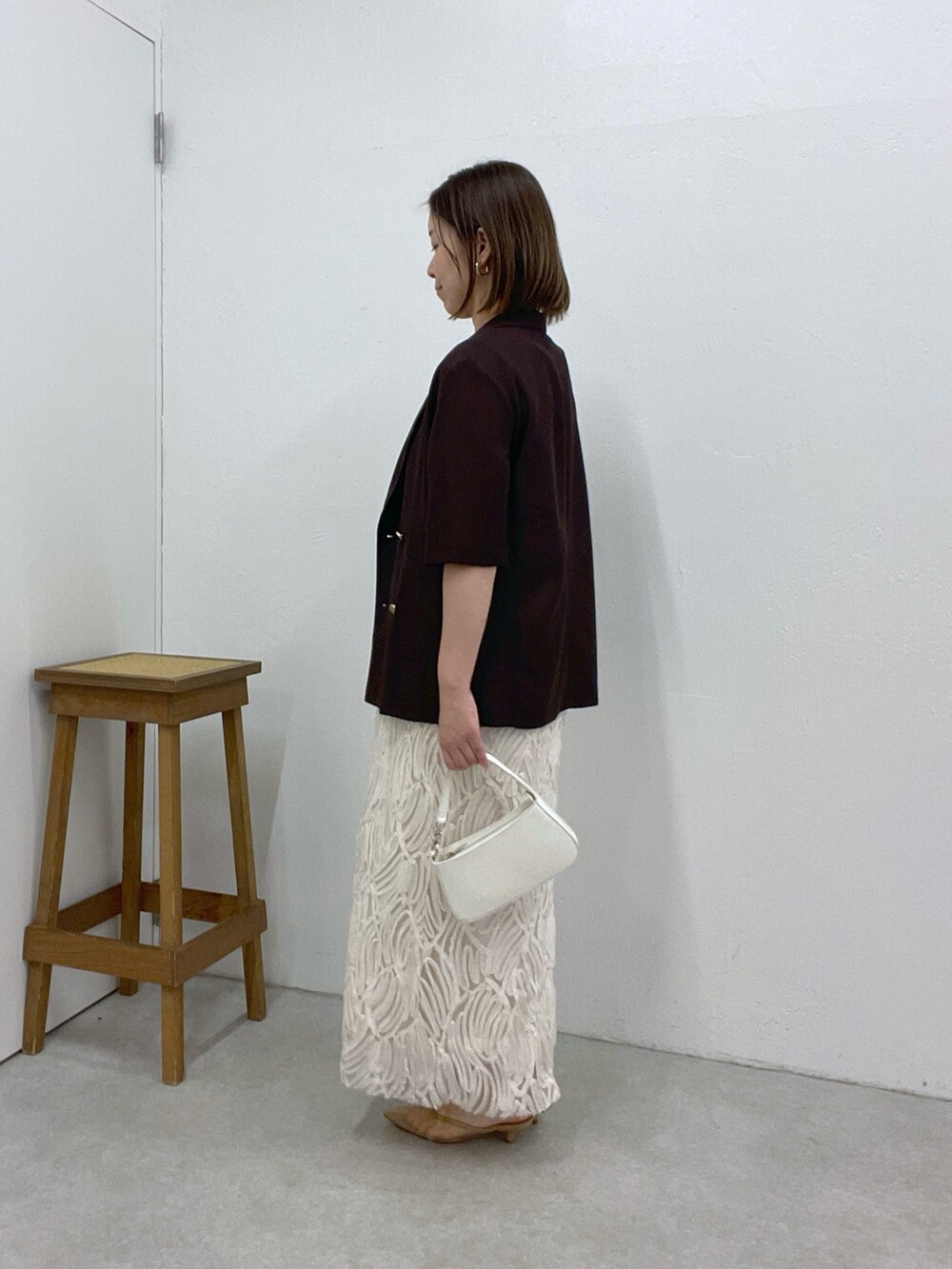 ホワイト系のワンピース、ブラウン系のテーラードジャケット、ホワイト系のショルダーバッグを着用したレディースの夏コーディネートの2枚目の写真