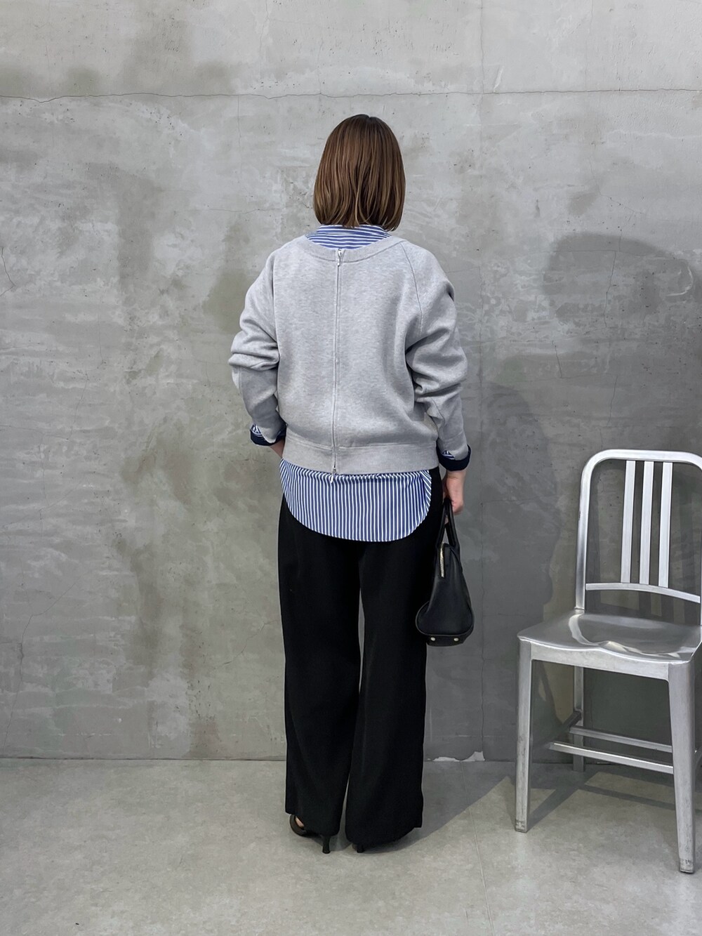 ブルー系のシャツ/ブラウス、ブラック系のその他パンツ、グレー系のニット/セーターを着用したレディースの夏コーディネートの3枚目の写真