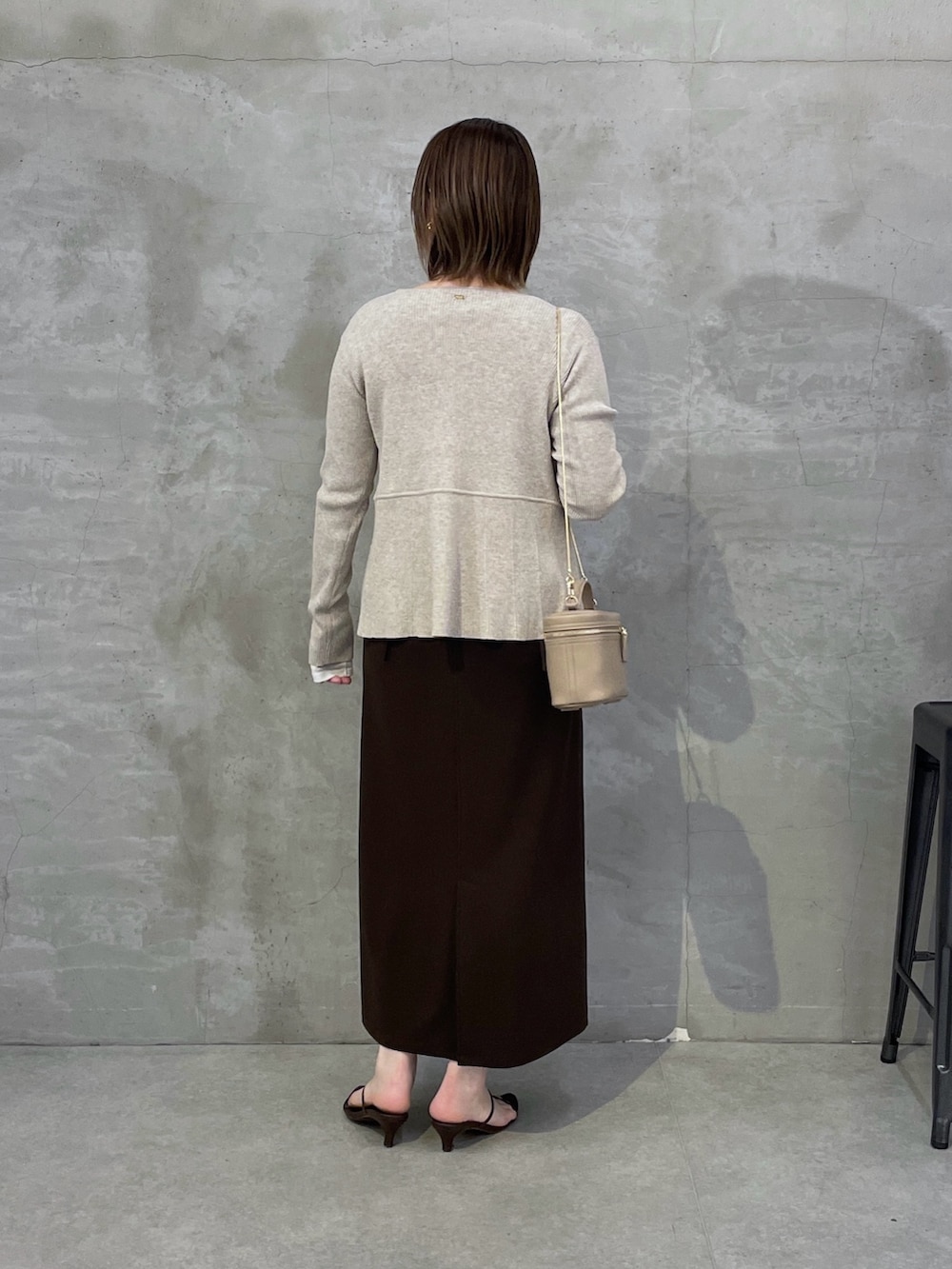 ベージュ系のカーディガン/ボレロ、ブラウン系のワンピース、ホワイト系のTシャツ/カットソーを着用したレディースの春コーディネートの3枚目の写真