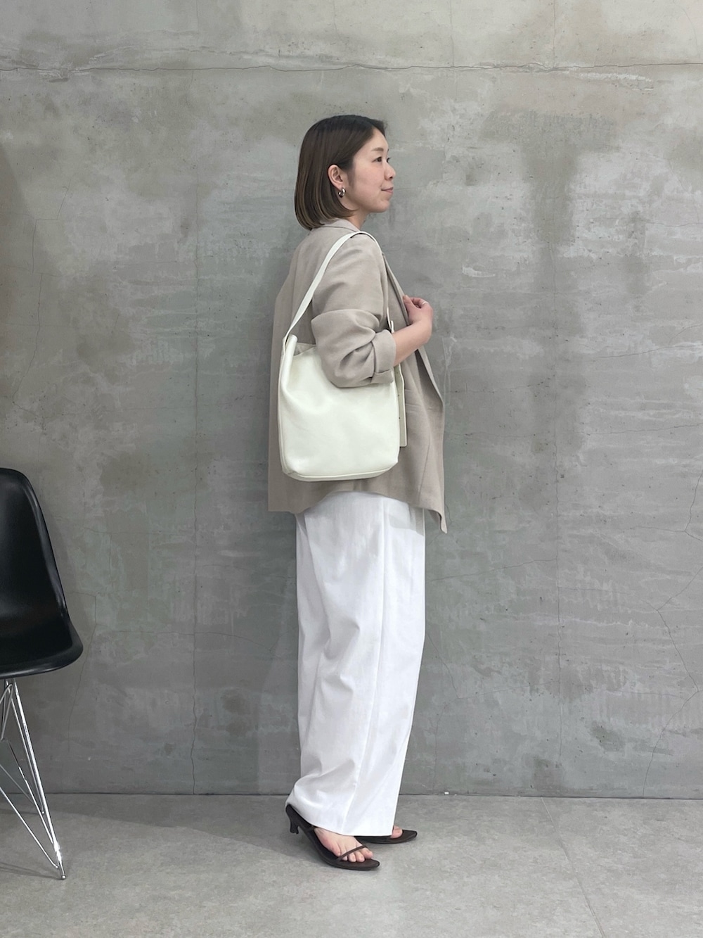 ベージュ系のテーラードジャケット、ブラウン系のTシャツ/カットソー、ホワイト系のスラックスを着用したレディースの春コーディネートの4枚目の写真