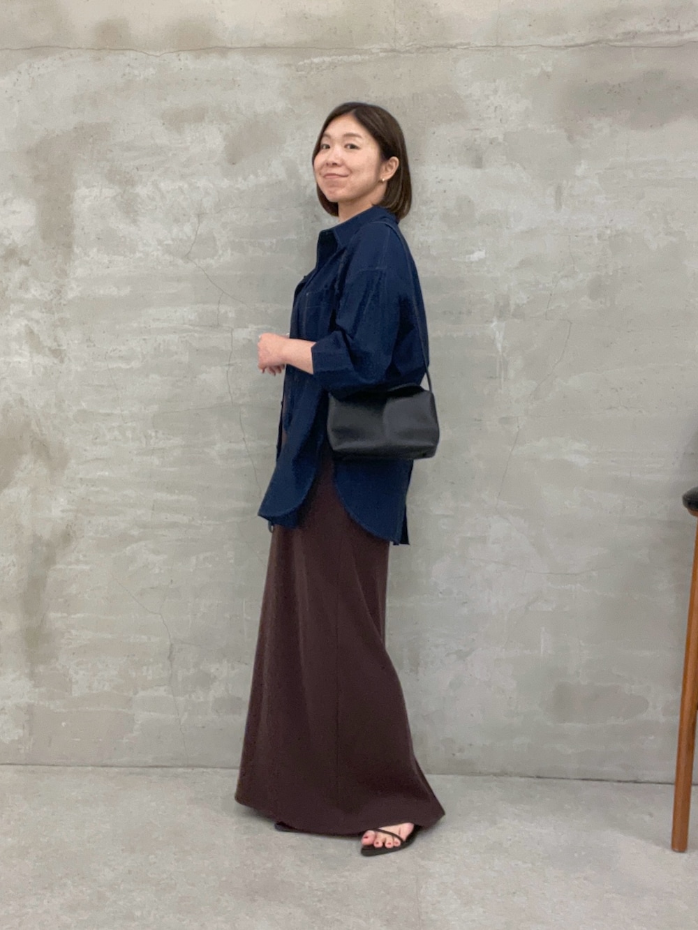 ブルー系のシャツ/ブラウス、ブラウン系のワンピース、ブラック系のショルダーバッグを着用したレディースの夏コーディネートの2枚目の写真