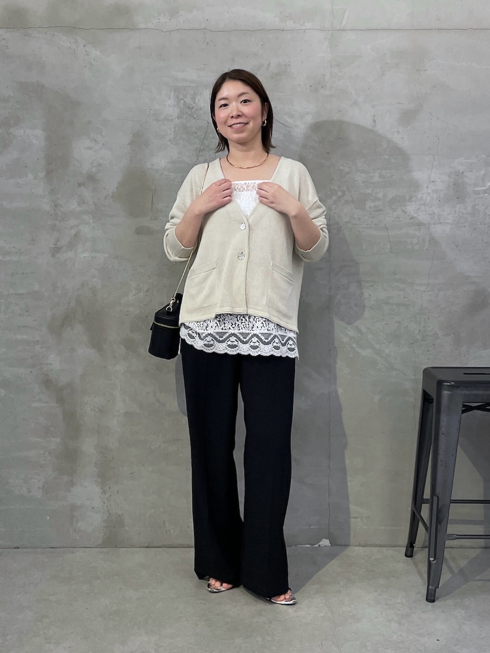 ベージュ系のカーディガン/ボレロ、ホワイト系のキャミソール、ブラック系のスラックスを着用したレディースの春コーディネートの4枚目の写真