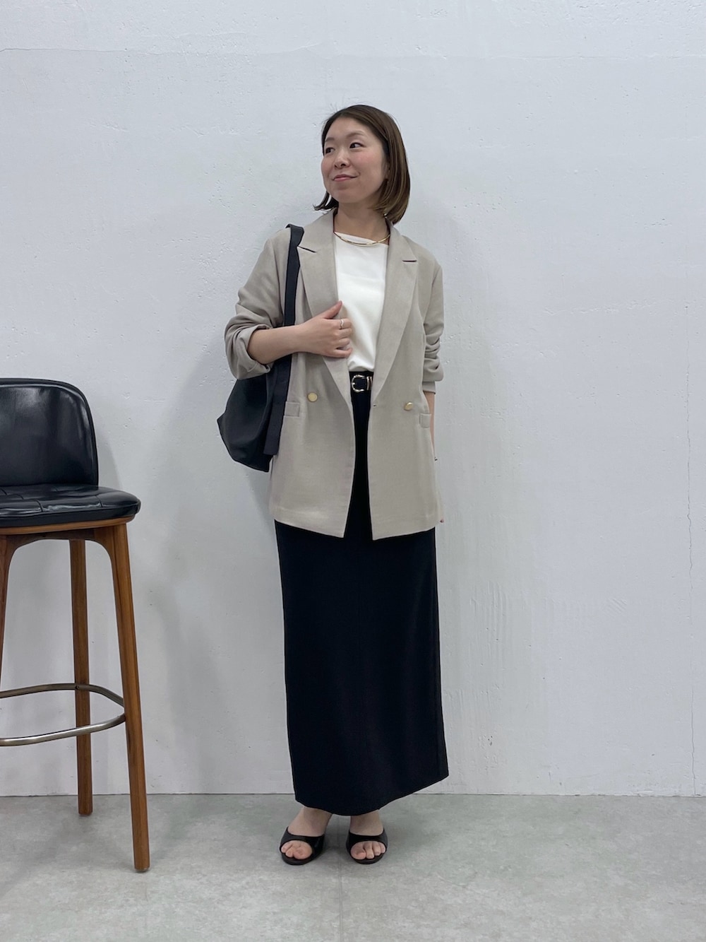 ブラック系のスカート、ベージュ系のテーラードジャケット、ホワイト系のシャツ/ブラウスを着用したレディースの春コーディネートの4枚目の写真