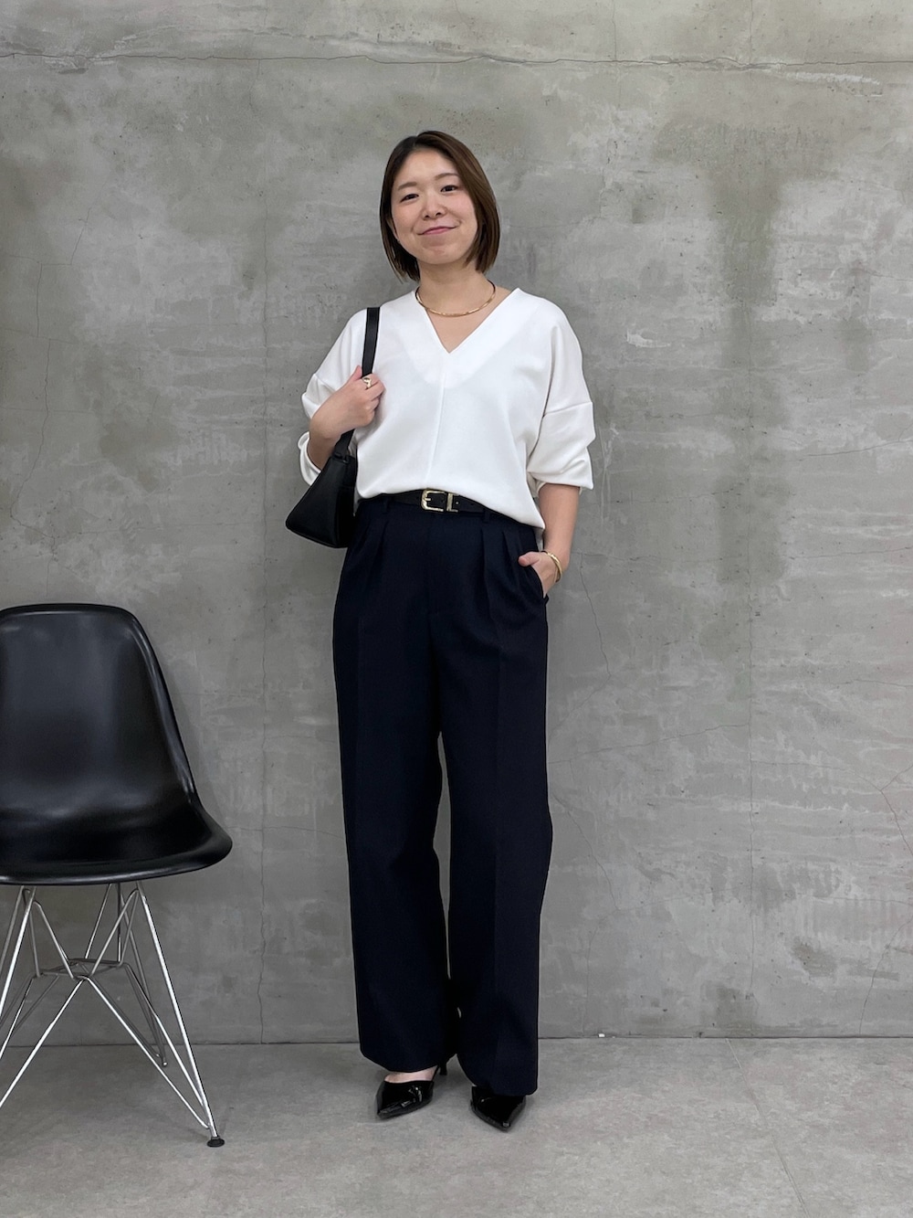 ホワイト系のTシャツ/カットソー、ブルー系のスラックス、ブラック系のベルトを着用したレディースの冬コーディネートの5枚目の写真