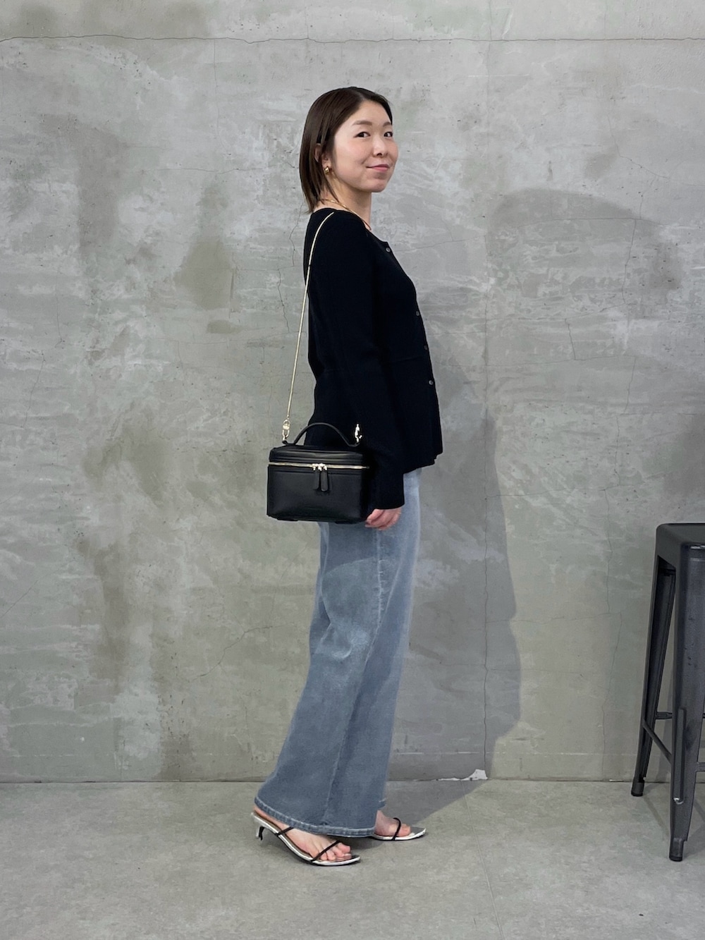 ブラック系のカーディガン/ボレロ、ブルー系のデニムパンツ、ブラック系のショルダーバッグを着用したレディースの春コーディネートの4枚目の写真