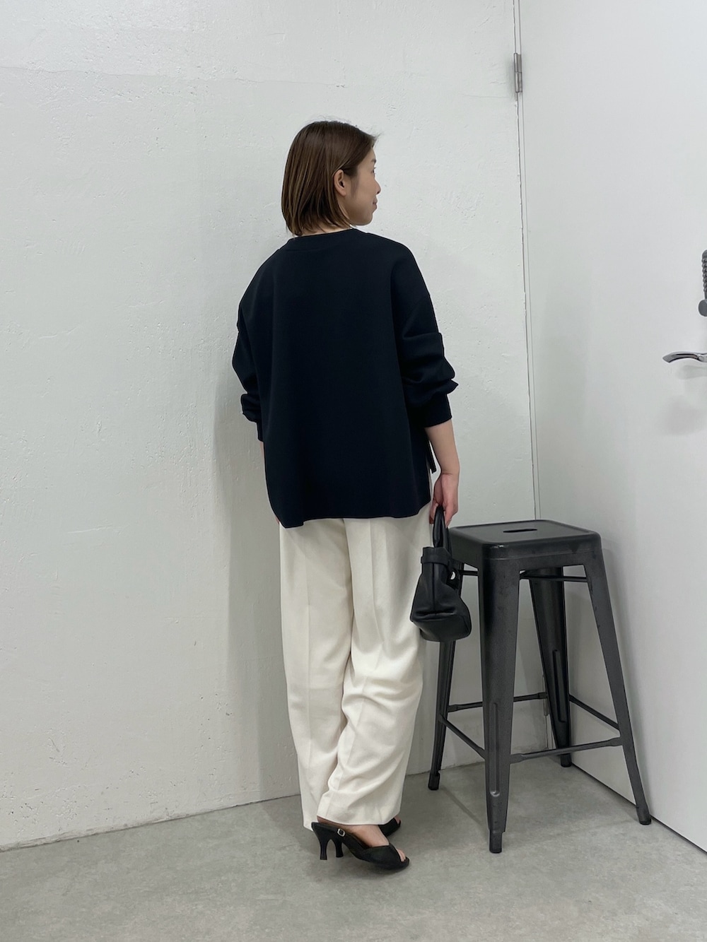 ブルー系のカーディガン/ボレロ、ホワイト系のスラックス、ブラック系のトートバッグを着用したレディースの春コーディネートの2枚目の写真