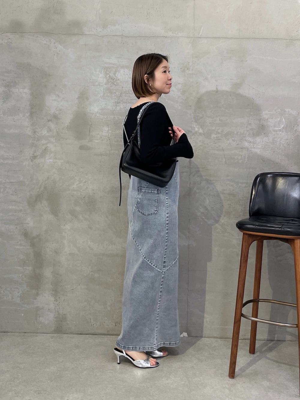 ブルー系のワンピース、ブラック系のニット/セーター、シルバー系のネックレスを着用したレディースの冬コーディネートの2枚目の写真