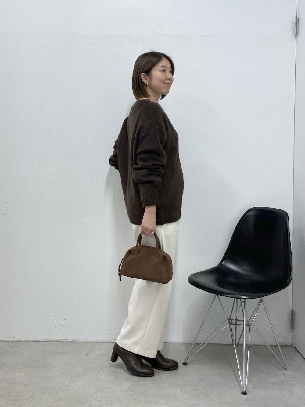 ブラウン系のニット/セーター、ホワイト系のその他パンツ、ブラウン系のボストンバッグを着用したレディースの冬コーディネートの4枚目の写真