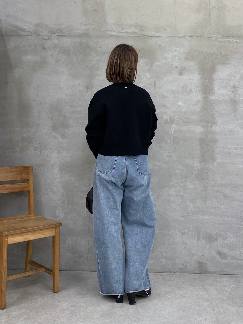 ブラック系のカーディガン/ボレロ、ブルー系のデニムパンツ、ホワイト系のTシャツ/カットソーを着用したレディースの冬コーディネートの3枚目の写真