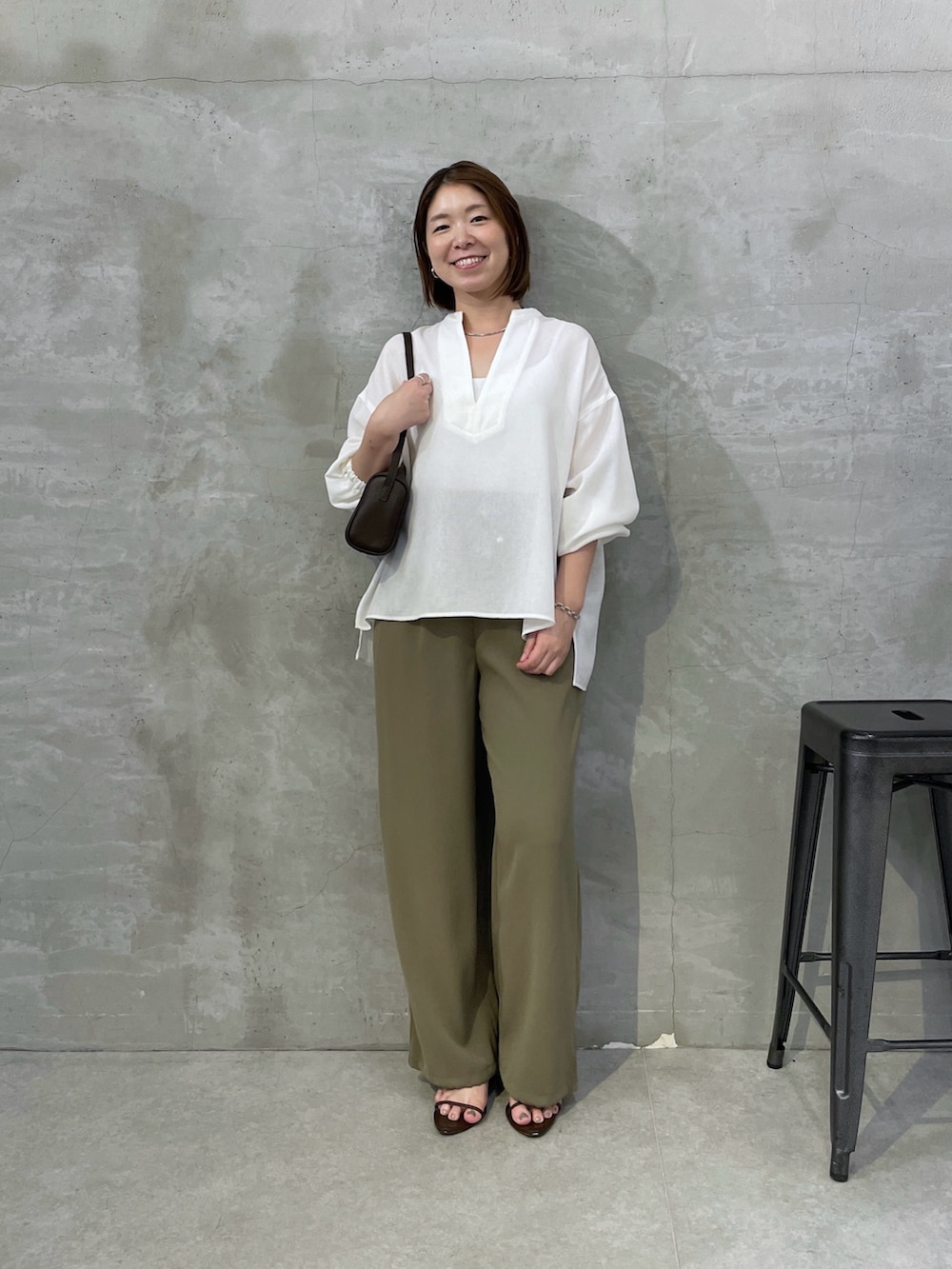 グリーン系のその他パンツ、ホワイト系のシャツ/ブラウス、ブラウン系のショルダーバッグを着用したレディースの夏コーディネートの5枚目の写真