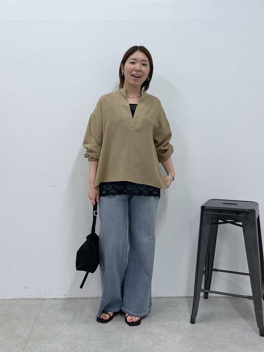 ベージュ系のシャツ/ブラウス、ブラック系のキャミソール、ブルー系のデニムパンツを着用したレディースの春コーディネートの5枚目の写真