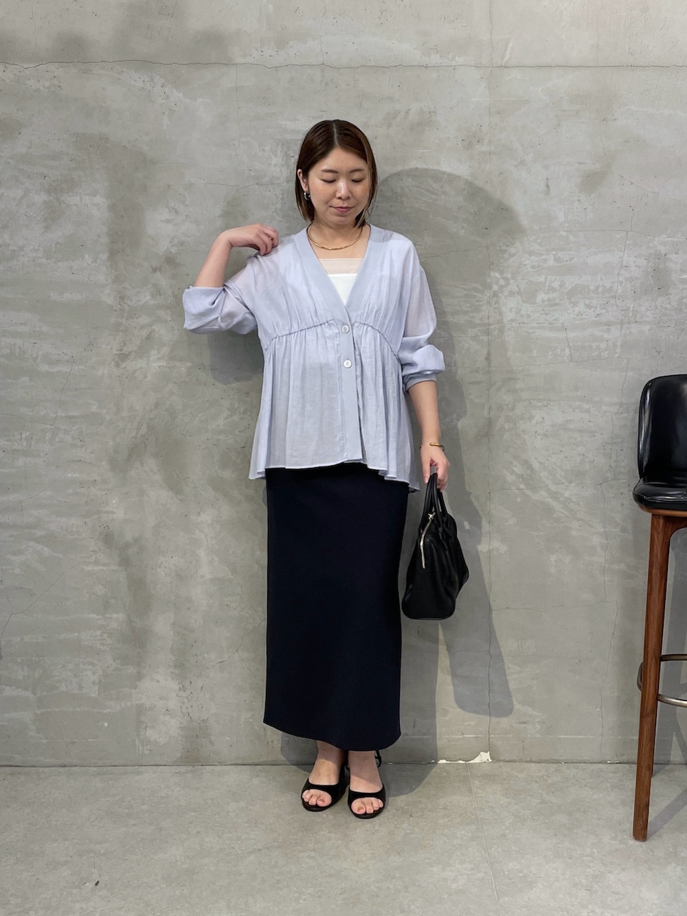 ブルー系のシャツ/ブラウス、ブラック系のスカート、ブラック系のボストンバッグを着用したレディースの夏コーディネートの4枚目の写真