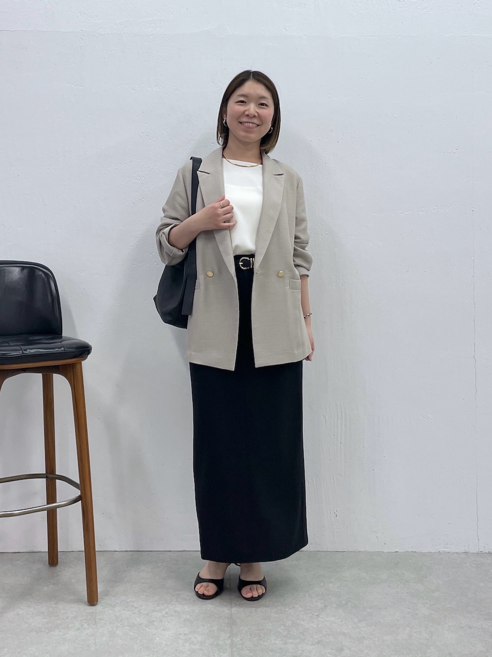 ブラック系のスカート、ベージュ系のテーラードジャケット、ホワイト系のシャツ/ブラウスを着用したレディースの春コーディネートの7枚目の写真