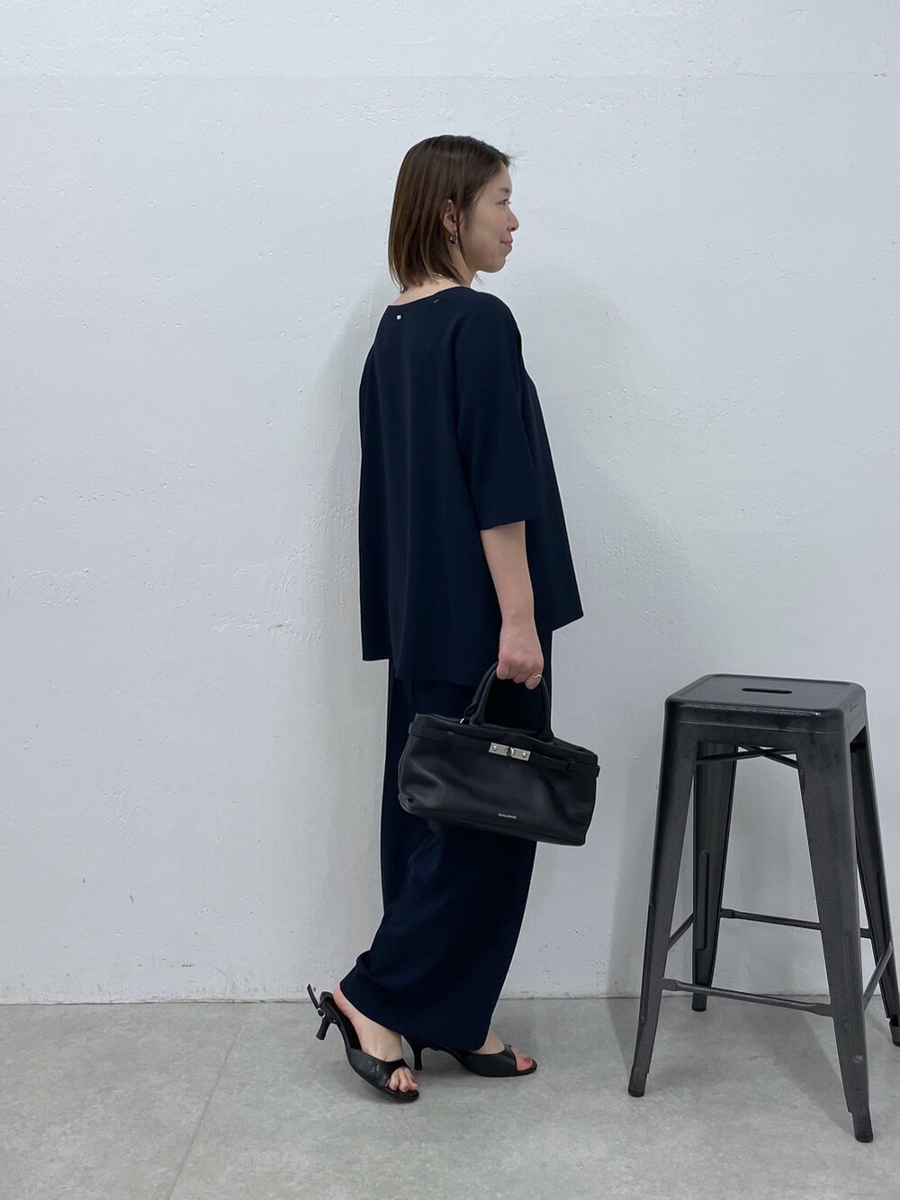 ブルー系のスラックス、ブルー系のシャツ/ブラウス、ブラック系のトートバッグを着用したレディースの春コーディネートの3枚目の写真