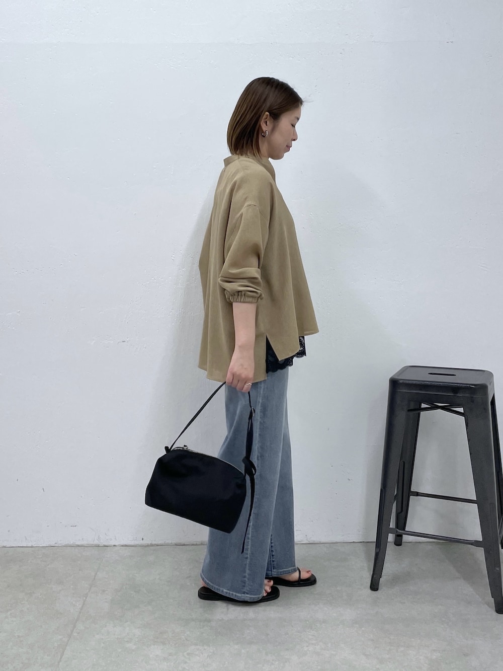 ベージュ系のシャツ/ブラウス、ブラック系のキャミソール、ブルー系のデニムパンツを着用したレディースの春コーディネートの4枚目の写真