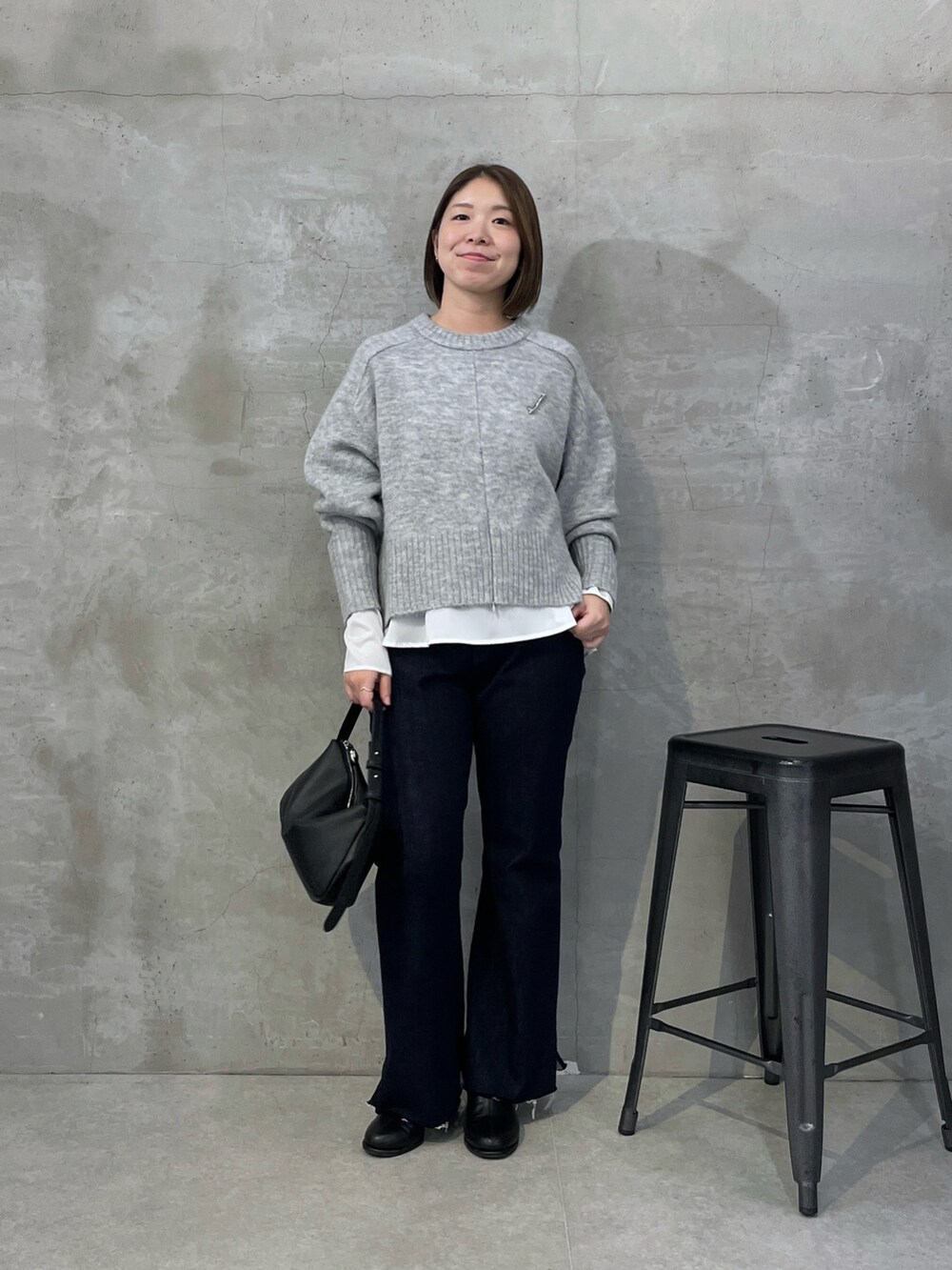 ホワイト系のシャツ/ブラウス、ブルー系のデニムパンツ、グレー系のニット/セーターを着用したレディースの秋コーディネートの5枚目の写真