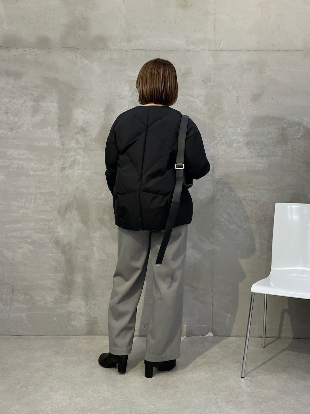 ブラック系のダウンジャケット/コート、グレー系のその他パンツ、ブラック系のニット/セーターを着用したレディースの秋コーディネートの2枚目の写真