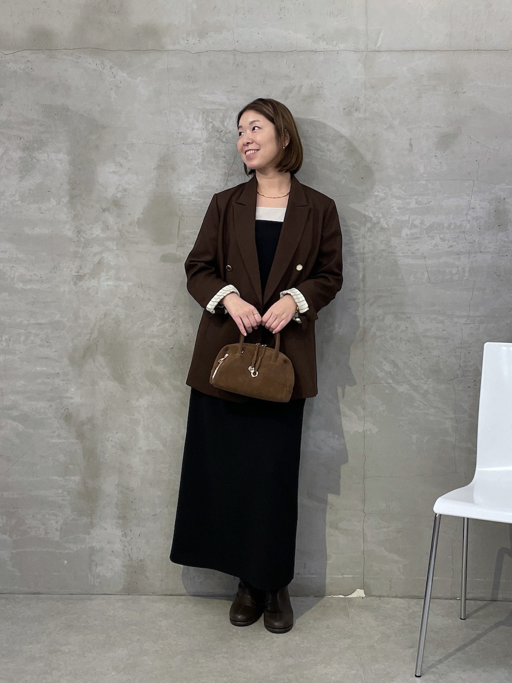 ブラウン系のテーラードジャケット、ブラック系のワンピース、ホワイト系のTシャツ/カットソーを着用したレディースの秋コーディネートの4枚目の写真