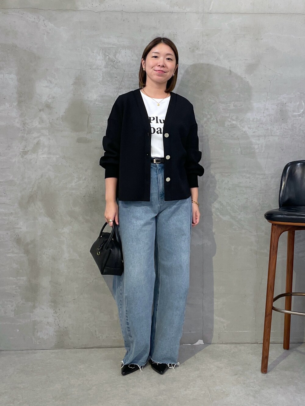 ブラック系のカーディガン/ボレロ、ブルー系のデニムパンツ、ホワイト系のTシャツ/カットソーを着用したレディースの秋コーディネートの4枚目の写真