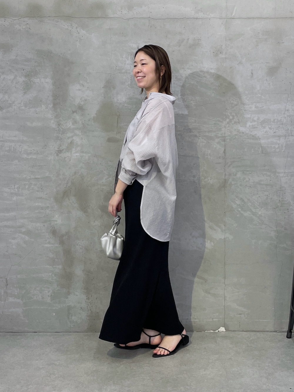 ブラック系のスカート、グレー系のシャツ/ブラウスを着用したレディースの春コーディネートの4枚目の写真