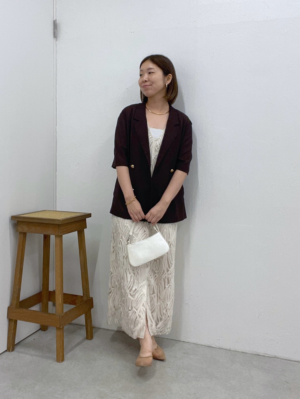ホワイト系のワンピース、ブラウン系のテーラードジャケット、ホワイト系のショルダーバッグを着用したレディースの夏コーディネートの4枚目の写真