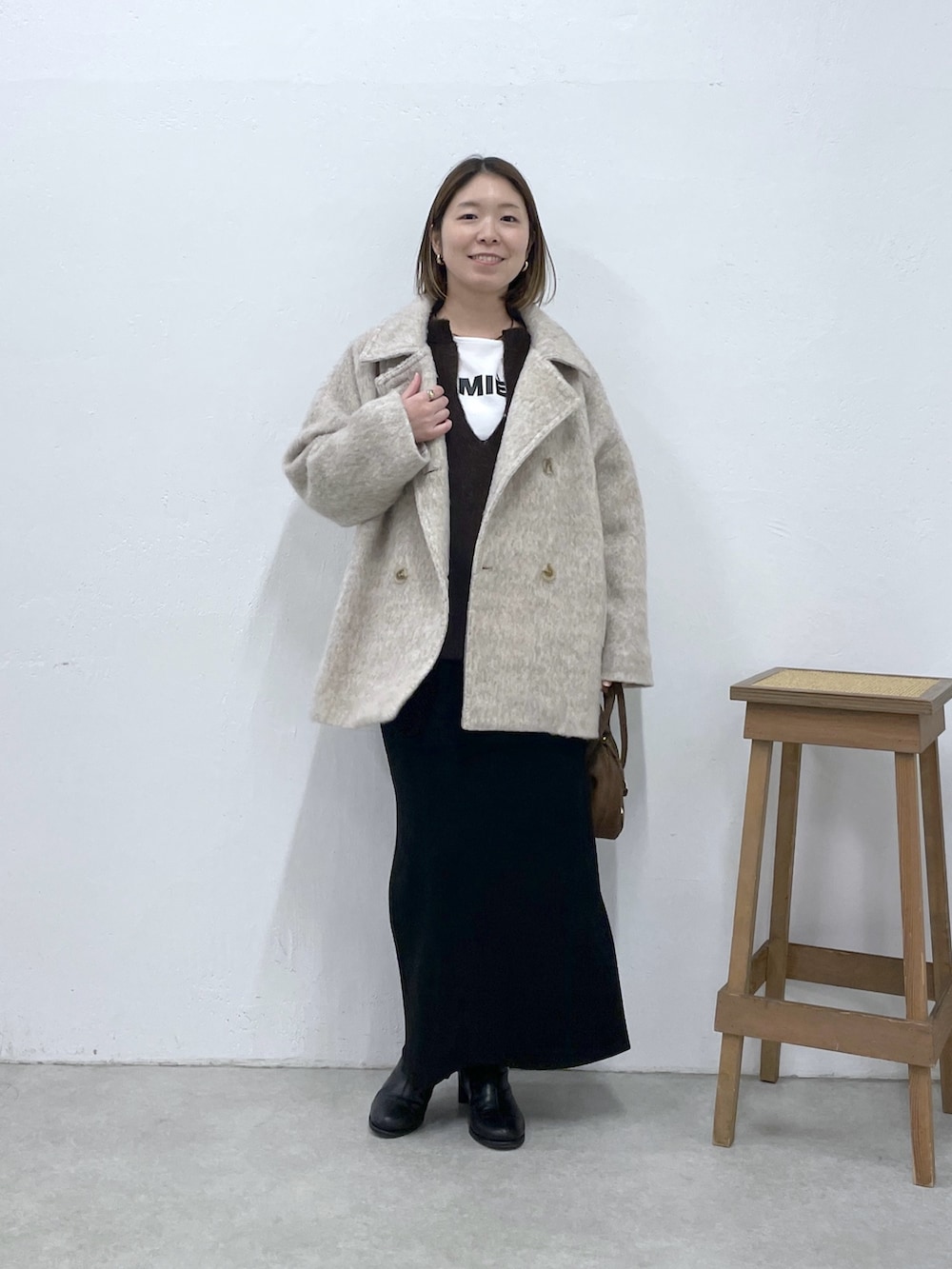 ベージュ系のその他アウター、ブラック系のスカート、ブラウン系のニット/セーターを着用したレディースの冬コーディネートの4枚目の写真