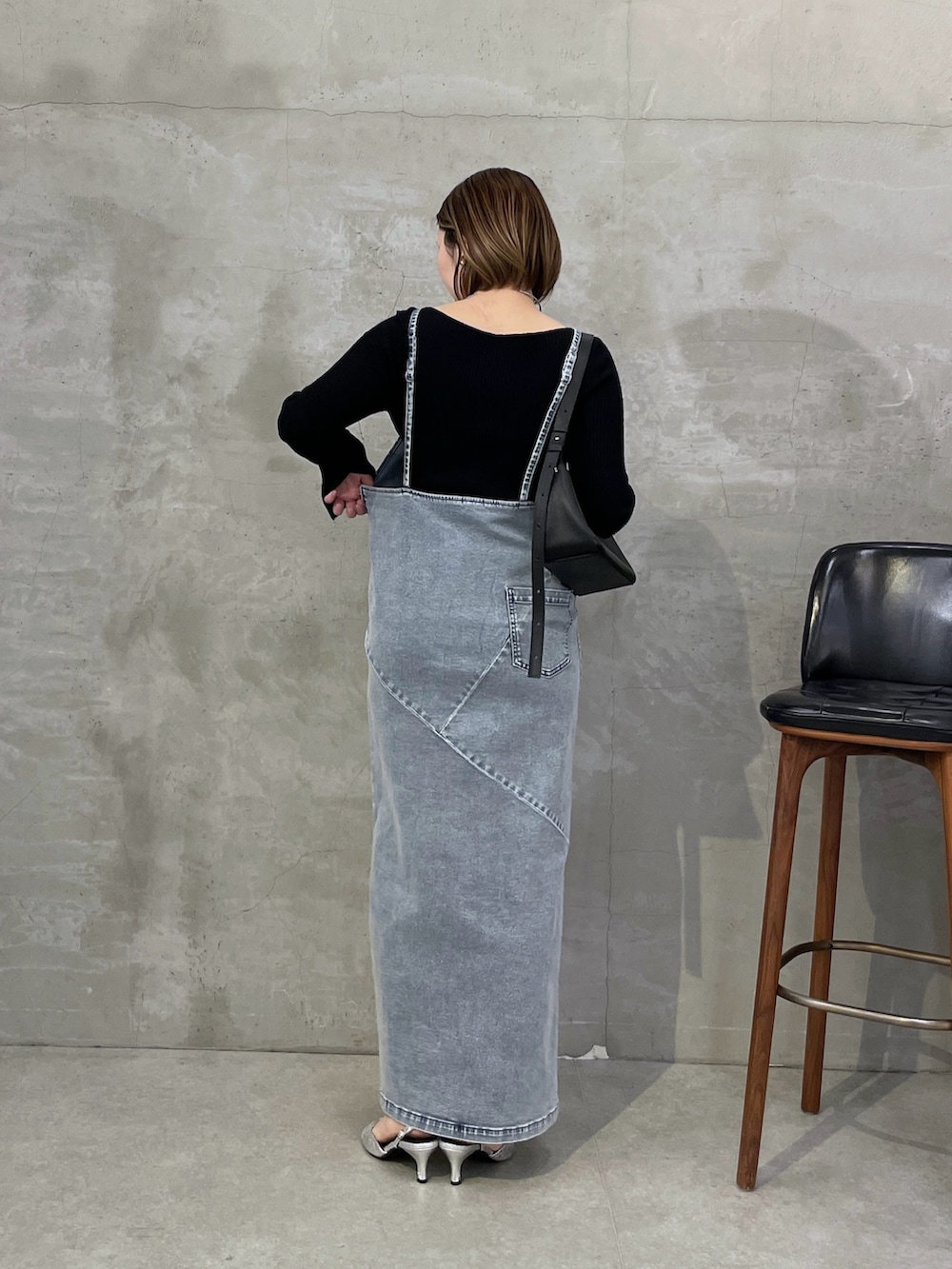 ブルー系のワンピース、ブラック系のニット/セーター、シルバー系のネックレスを着用したレディースの冬コーディネートの3枚目の写真