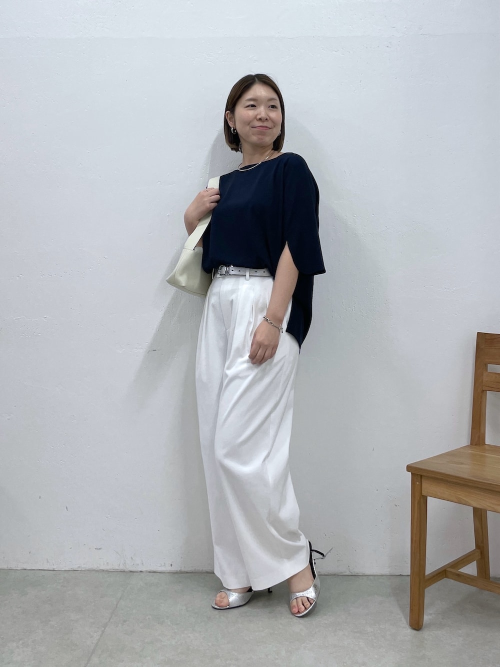 ブルー系のシャツ/ブラウス、ホワイト系のスラックス、ホワイト系のショルダーバッグを着用したレディースの春コーディネートの4枚目の写真