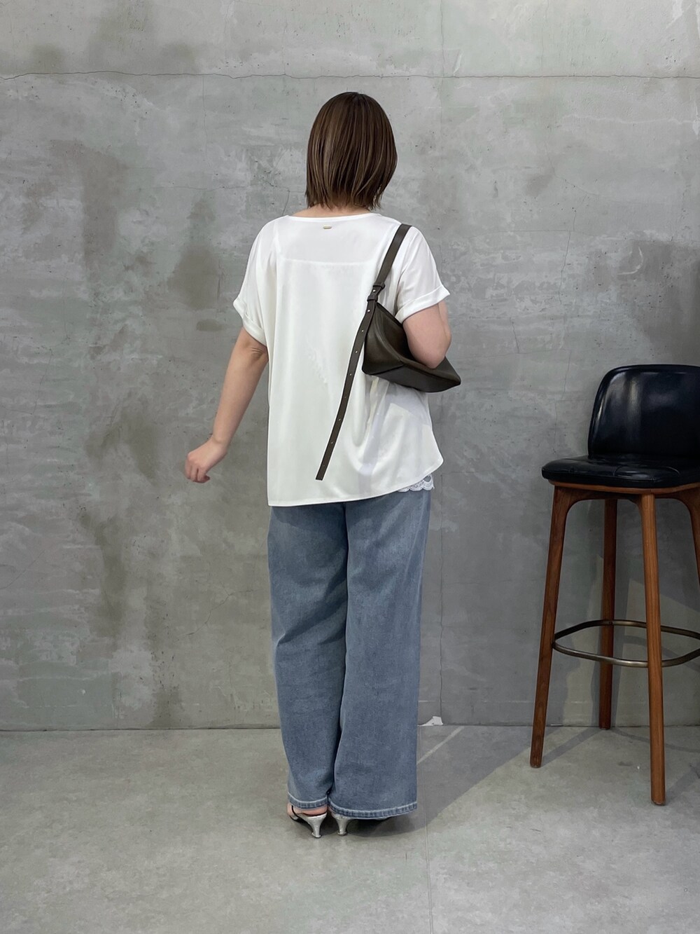 ホワイト系のTシャツ/カットソー、ホワイト系のキャミソール、ブルー系のデニムパンツを着用したレディースの春コーディネートの3枚目の写真
