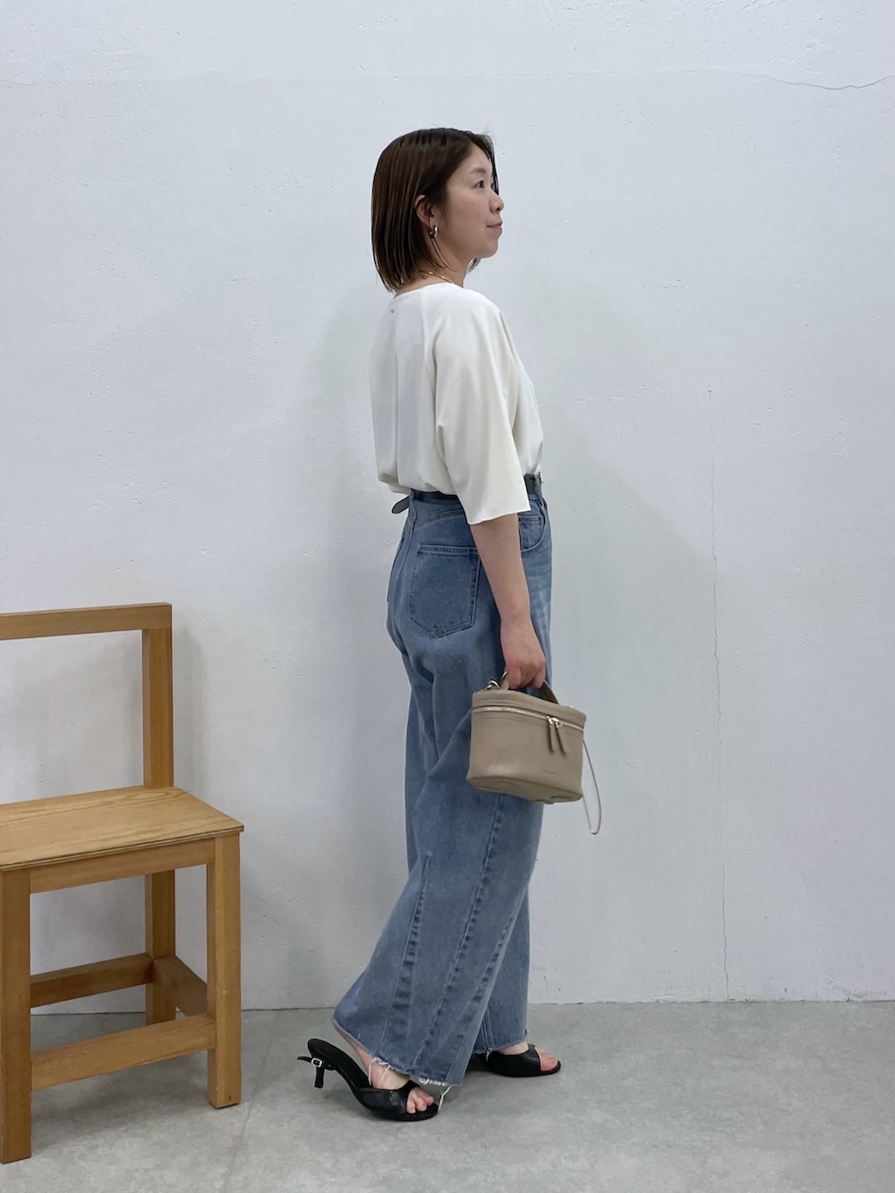 ホワイト系のシャツ/ブラウス、ブルー系のデニムパンツ、ベージュ系のショルダーバッグを着用したレディースの春コーディネートの2枚目の写真