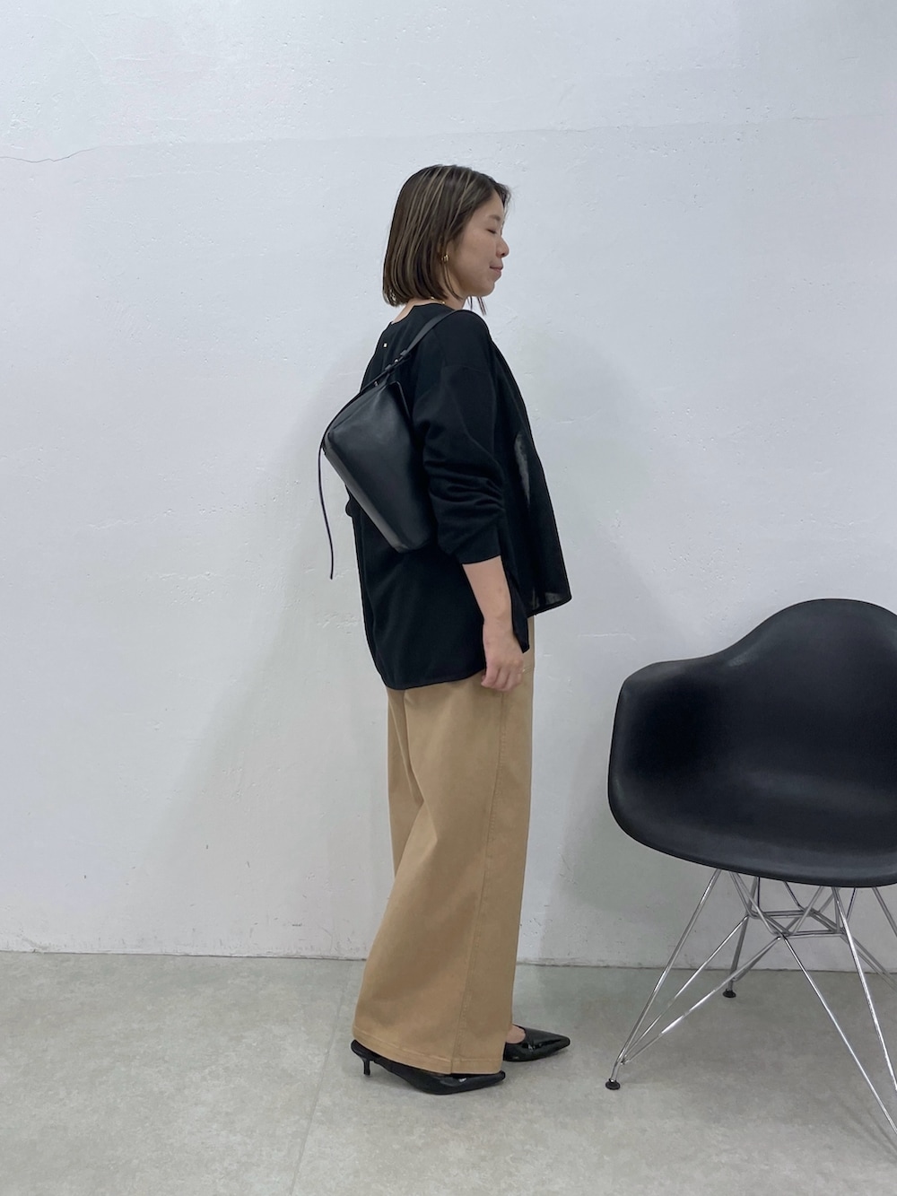 ホワイト系のタンクトップ、ベージュ系のデニムパンツ、ブラック系のカーディガン/ボレロを着用したレディースの夏コーディネートの2枚目の写真