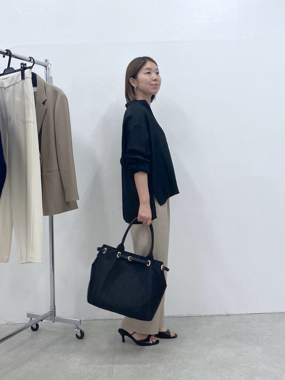 ブラック系のシャツ/ブラウス、ベージュ系のその他パンツ、ブラック系のトートバッグを着用したレディースの夏コーディネートの2枚目の写真
