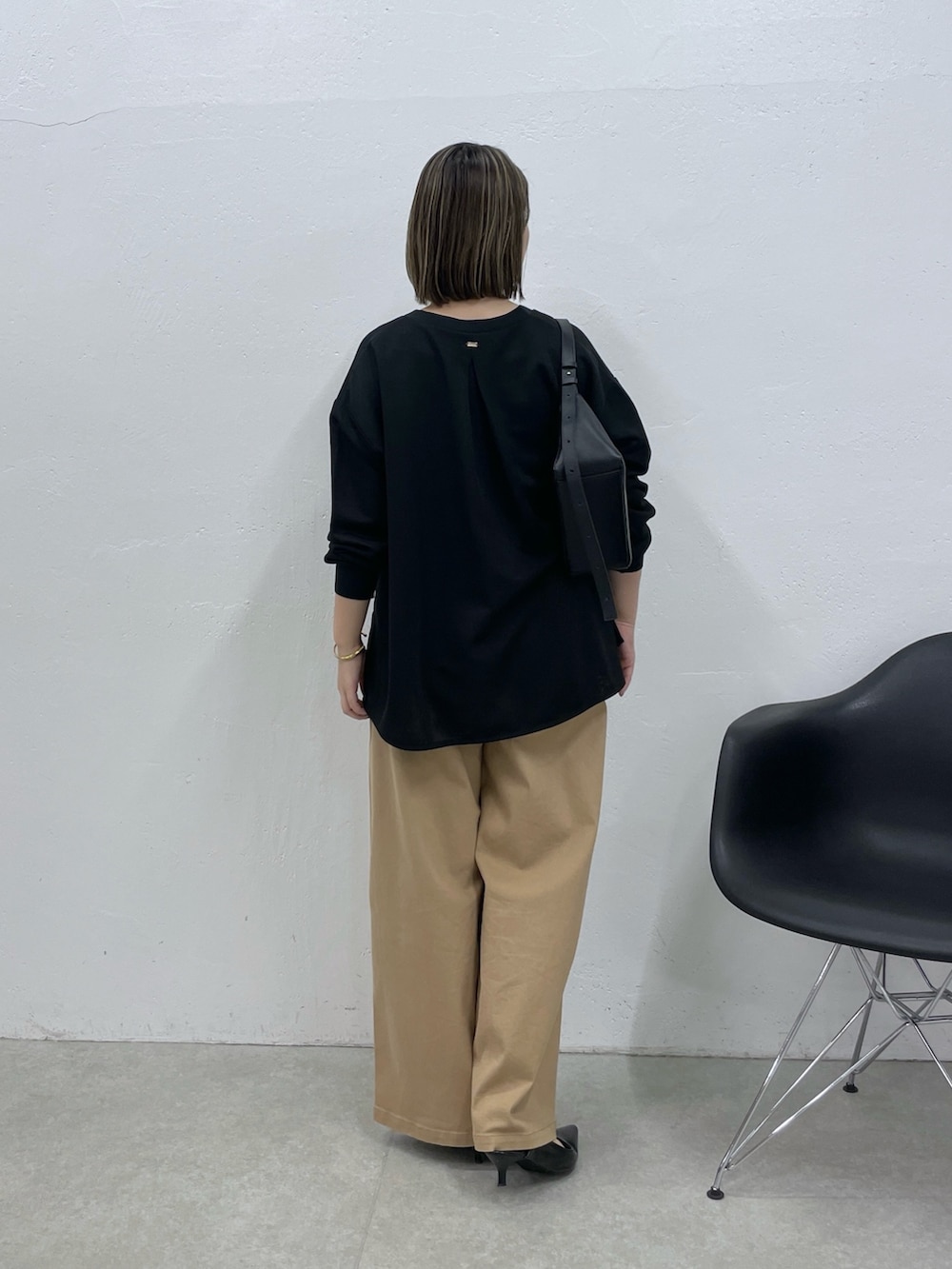 ホワイト系のタンクトップ、ベージュ系のデニムパンツ、ブラック系のカーディガン/ボレロを着用したレディースの夏コーディネートの3枚目の写真