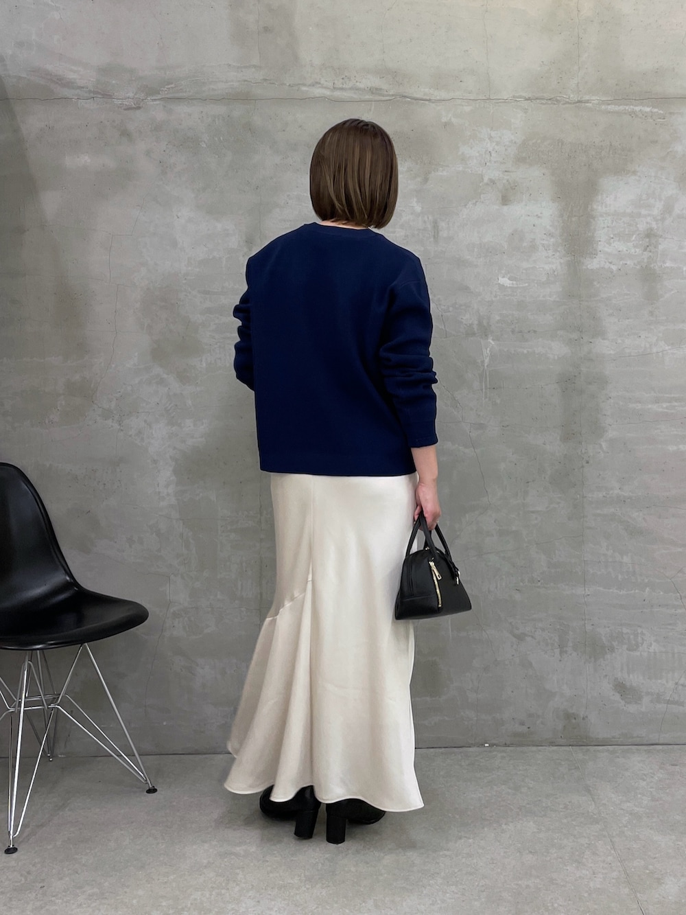 ホワイト系のスカート、ブルー系のカーディガン/ボレロ、ブラック系のボストンバッグを着用したレディースの冬コーディネートの3枚目の写真