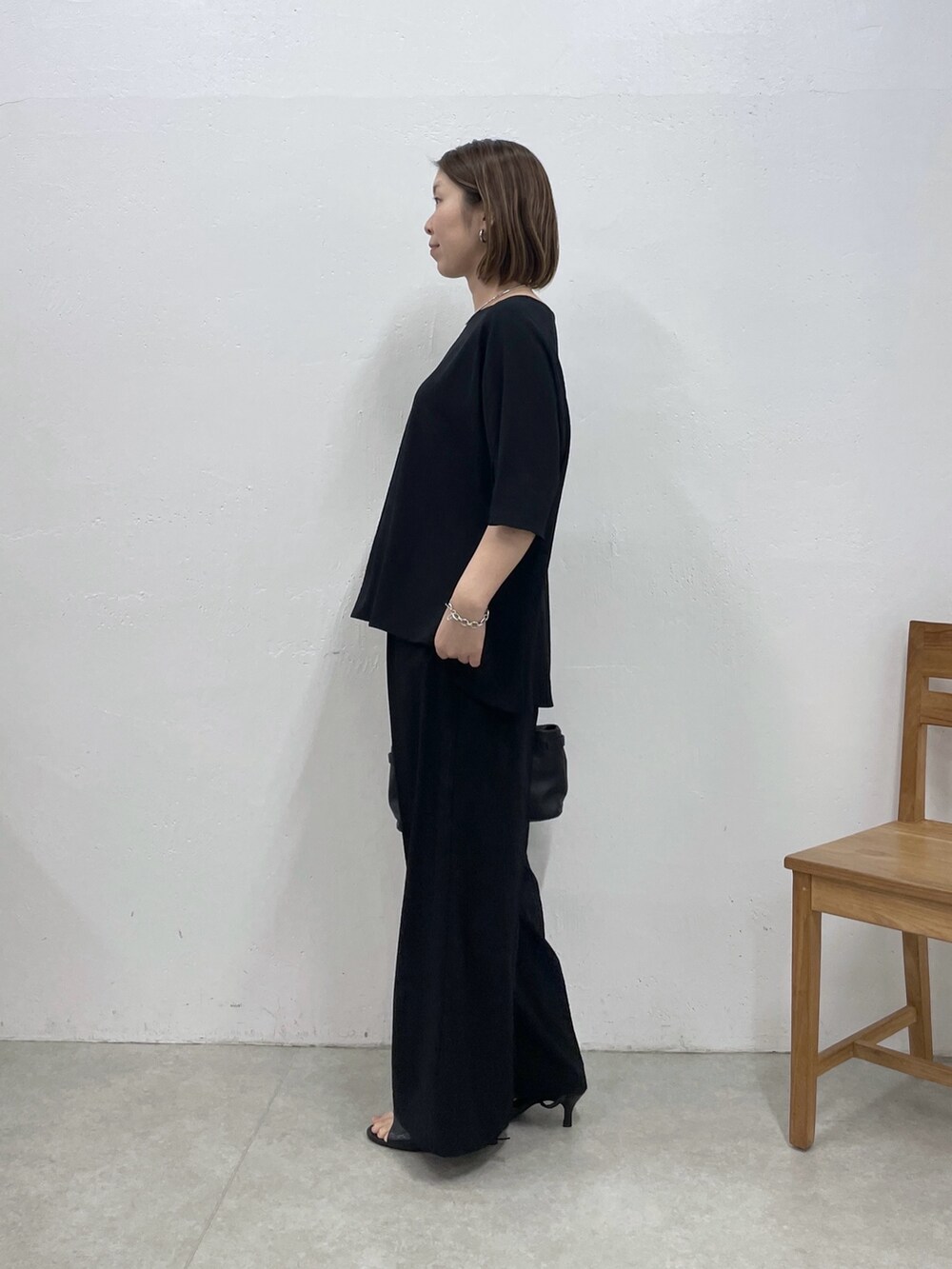 ブラック系のシャツ/ブラウス、ブラック系のスラックス、ブラック系のトートバッグを着用したレディースの春コーディネートの2枚目の写真