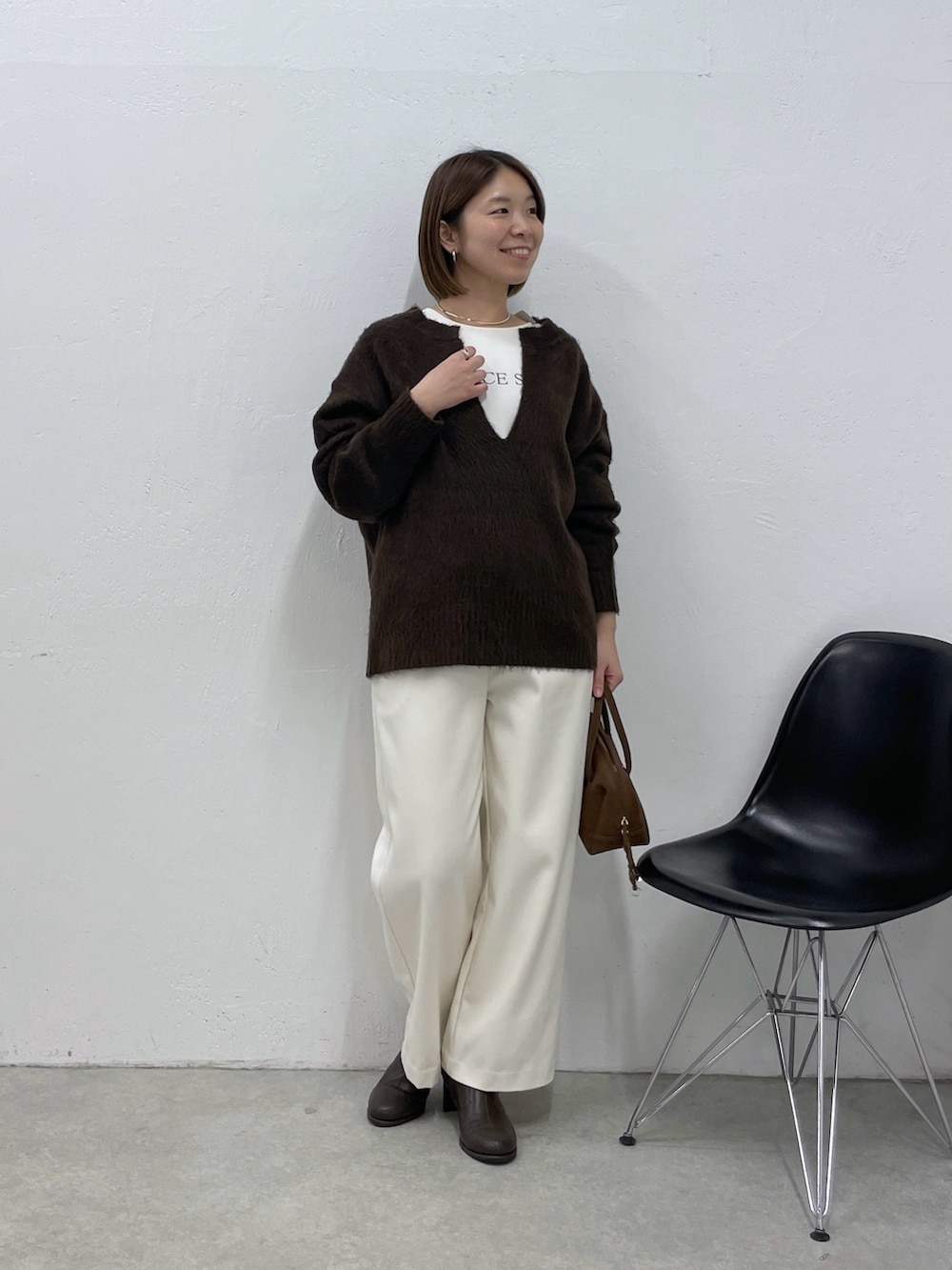 ブラウン系のニット/セーター、ホワイト系のその他パンツ、ブラウン系のボストンバッグを着用したレディースの冬コーディネートの5枚目の写真