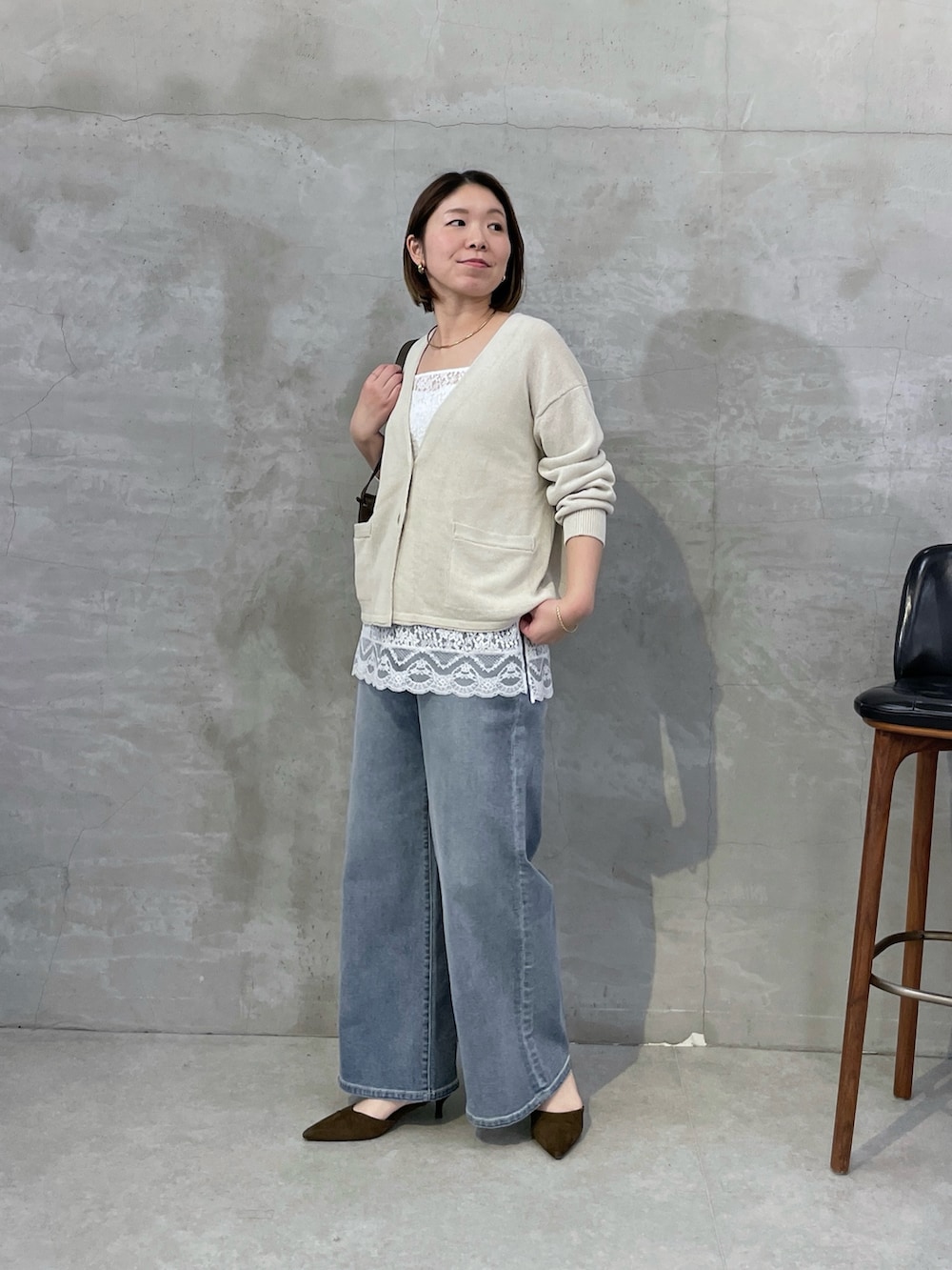 ベージュ系のカーディガン/ボレロ、ホワイト系のキャミソール、ブルー系のデニムパンツを着用したレディースの冬コーディネートの4枚目の写真
