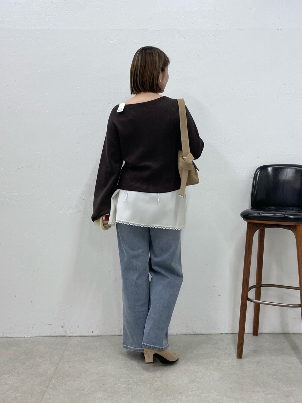 ブラウン系のニット/セーター、ホワイト系のキャミソール、ブルー系のデニムパンツを着用したレディースの秋コーディネートの3枚目の写真