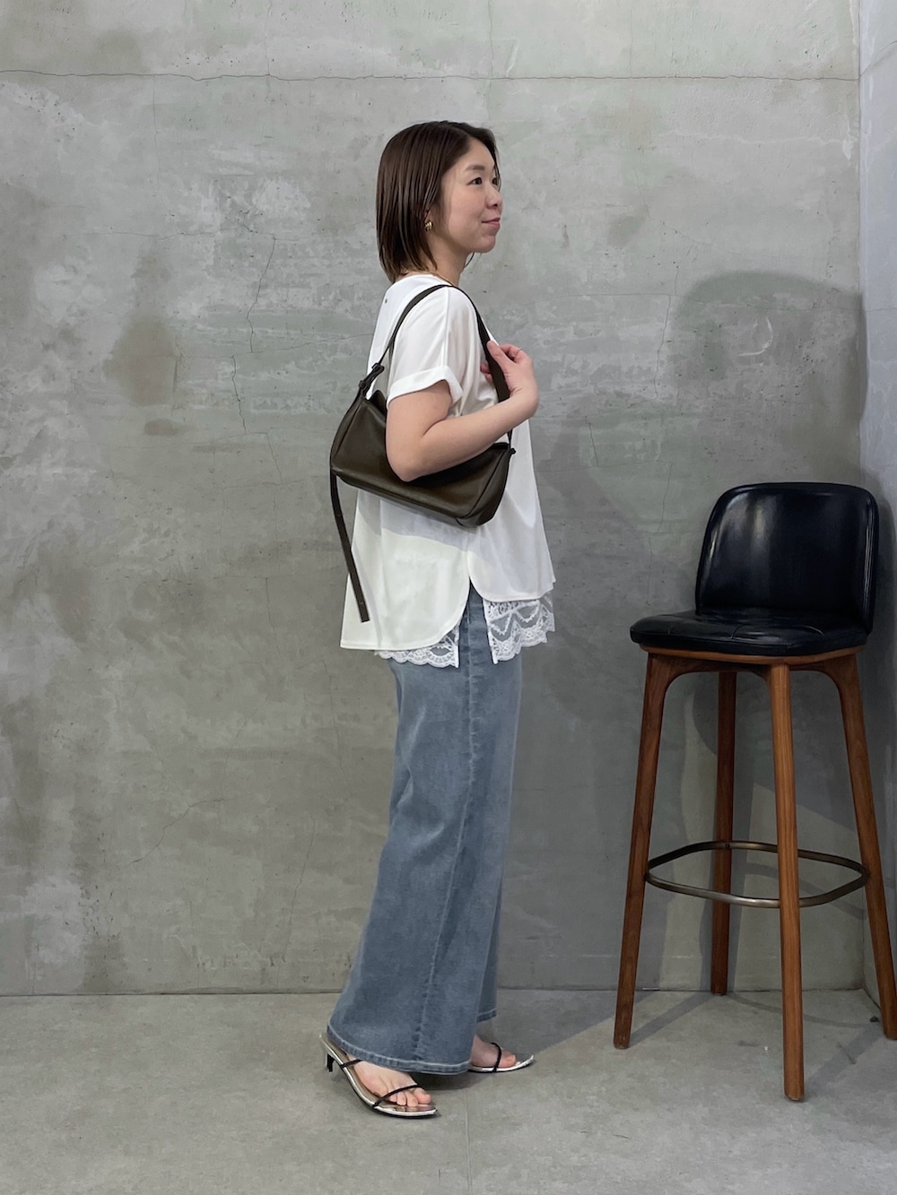 ホワイト系のTシャツ/カットソー、ホワイト系のキャミソール、ブルー系のデニムパンツを着用したレディースの春コーディネートの4枚目の写真