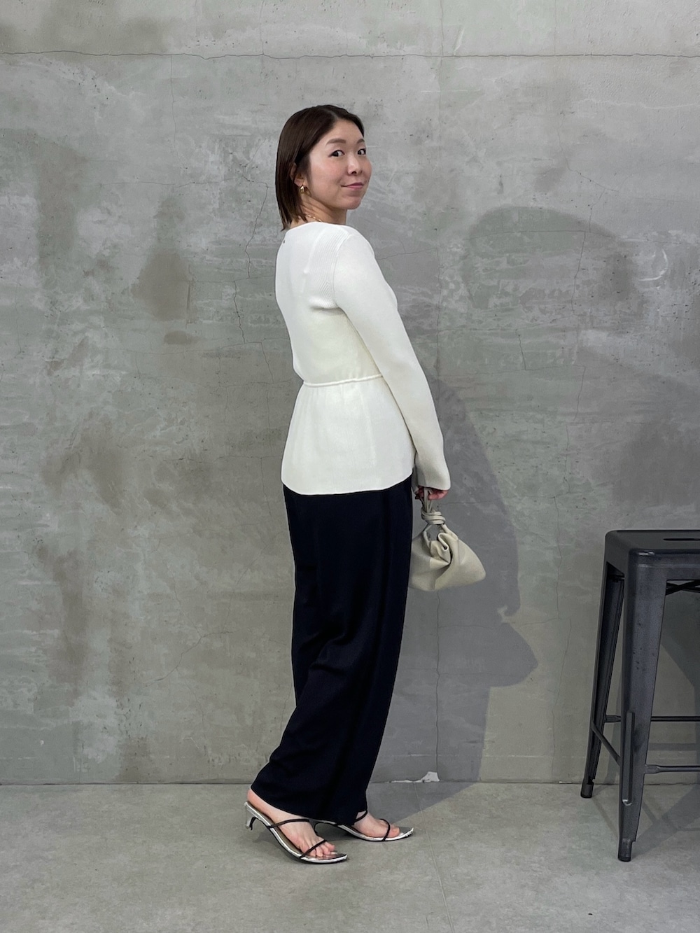 ブルー系のスラックス、ホワイト系のカーディガン/ボレロ、ゴールド系のネックレスを着用したレディースの春コーディネートの2枚目の写真