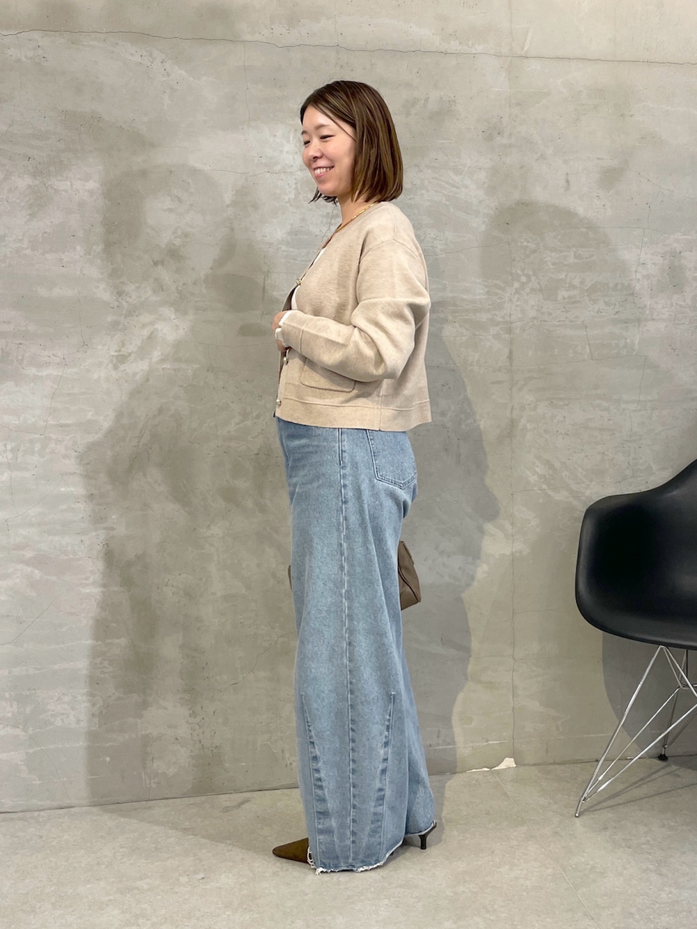 ブルー系のデニムパンツ、ベージュ系のカーディガン/ボレロ、ホワイト系のTシャツ/カットソーを着用したレディースの秋コーディネートの4枚目の写真