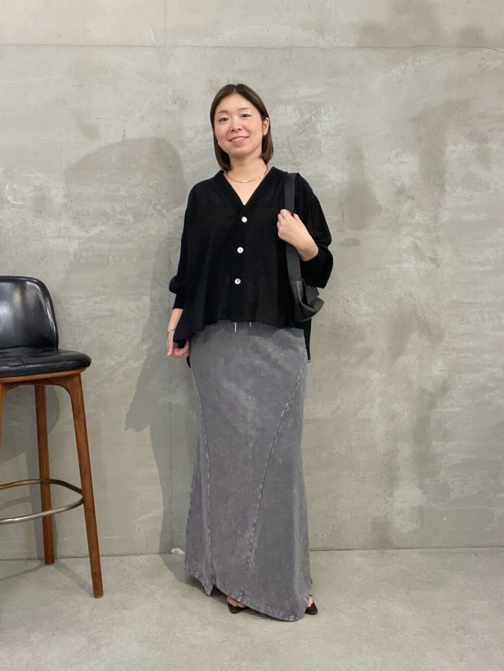 グレー系のスカート、ブラック系のシャツ/ブラウス、ブラック系のバッグを着用したレディースの夏コーディネートの5枚目の写真