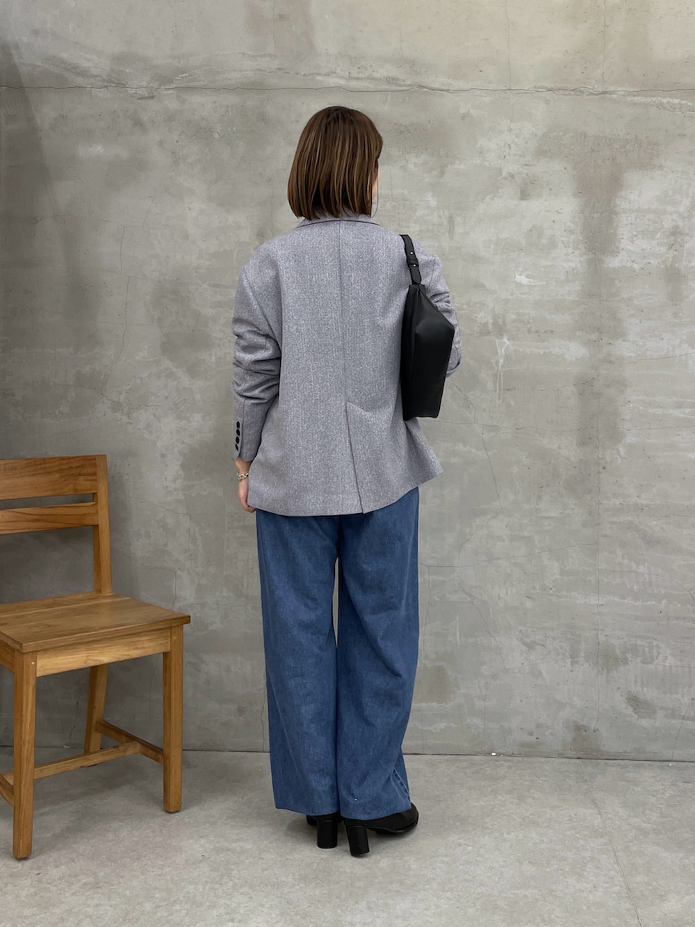 グレー系のテーラードジャケット、ブルー系のデニムパンツ、ブラック系のTシャツ/カットソーを着用したレディースの冬コーディネートの3枚目の写真