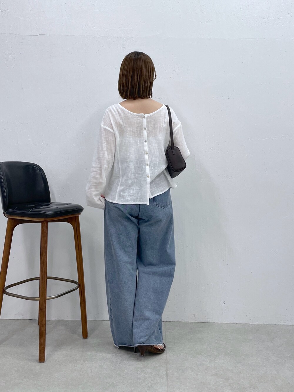 ホワイト系のシャツ/ブラウス、ブルー系のデニムパンツ、ブラック系のショルダーバッグを着用したレディースの夏コーディネートの3枚目の写真