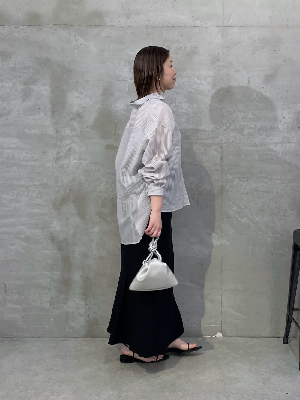 ブラック系のスカート、グレー系のシャツ/ブラウスを着用したレディースの春コーディネートの2枚目の写真